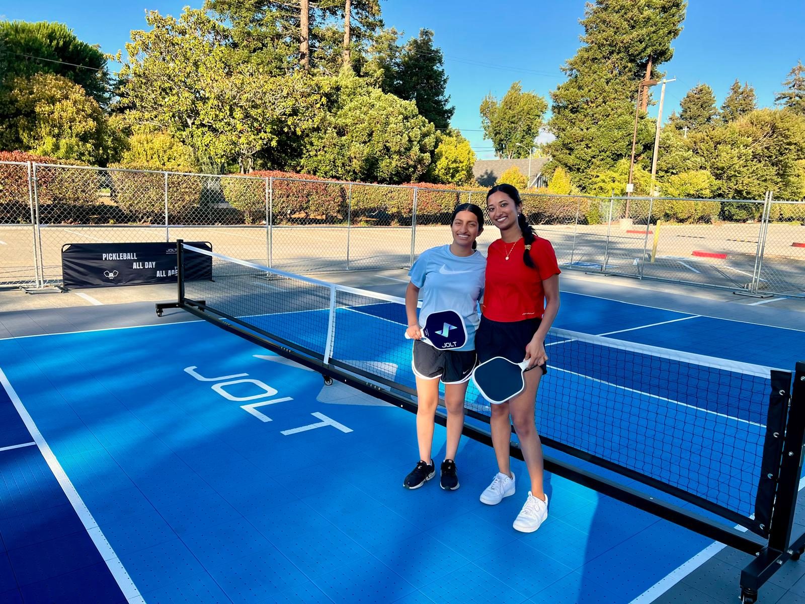 Two players posing court-side with Jolt paddles